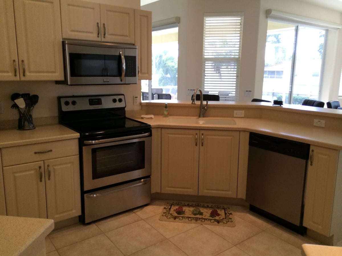 A kitchen with a microwave, oven, sink, and dishwasher.
