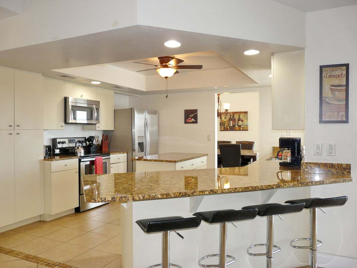 Kitchen with granite counters, a breakfast bar, and stainless appliances