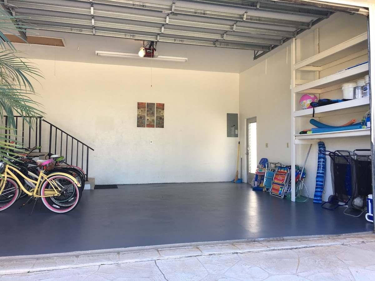 Garage with bikes on one side and beach gear on shelves