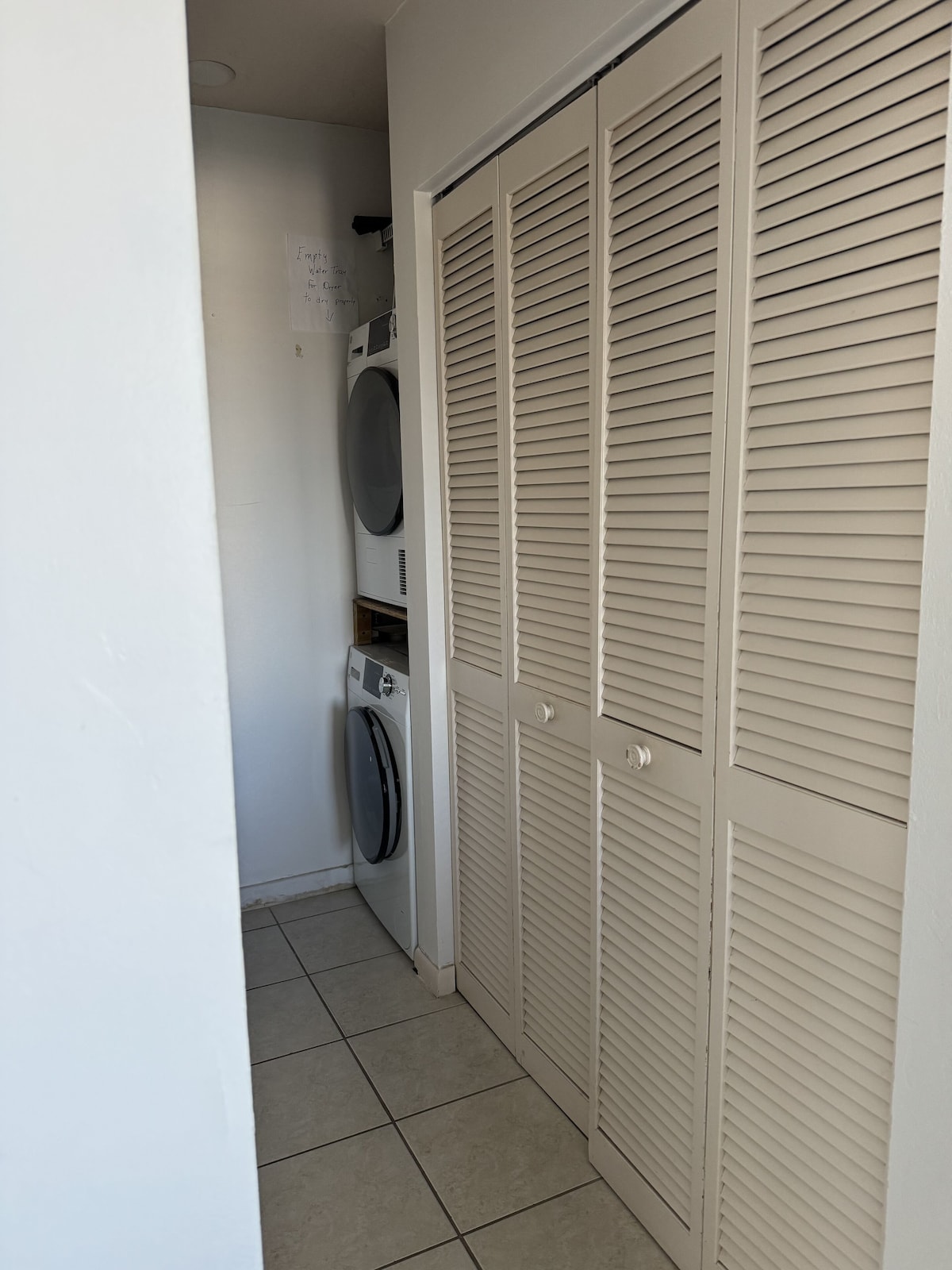A laundry room with a washing machine, dryer, and a wall-mounted heater.