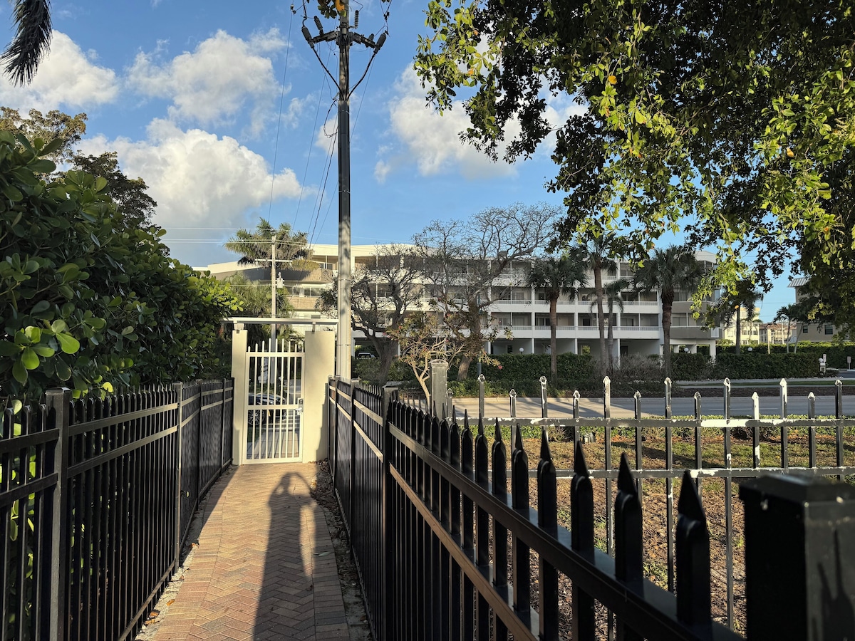 A pathway leading to a gated entrance with a building in the background.