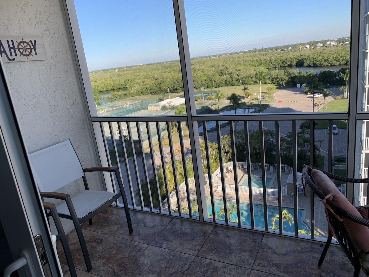 A balcony with a view of a swimming pool and a distant landscape.