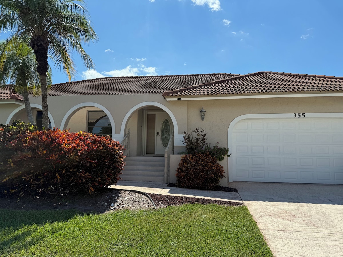 A residential house with a tiled roof, a garage numbered 355, and a well-maintained lawn.