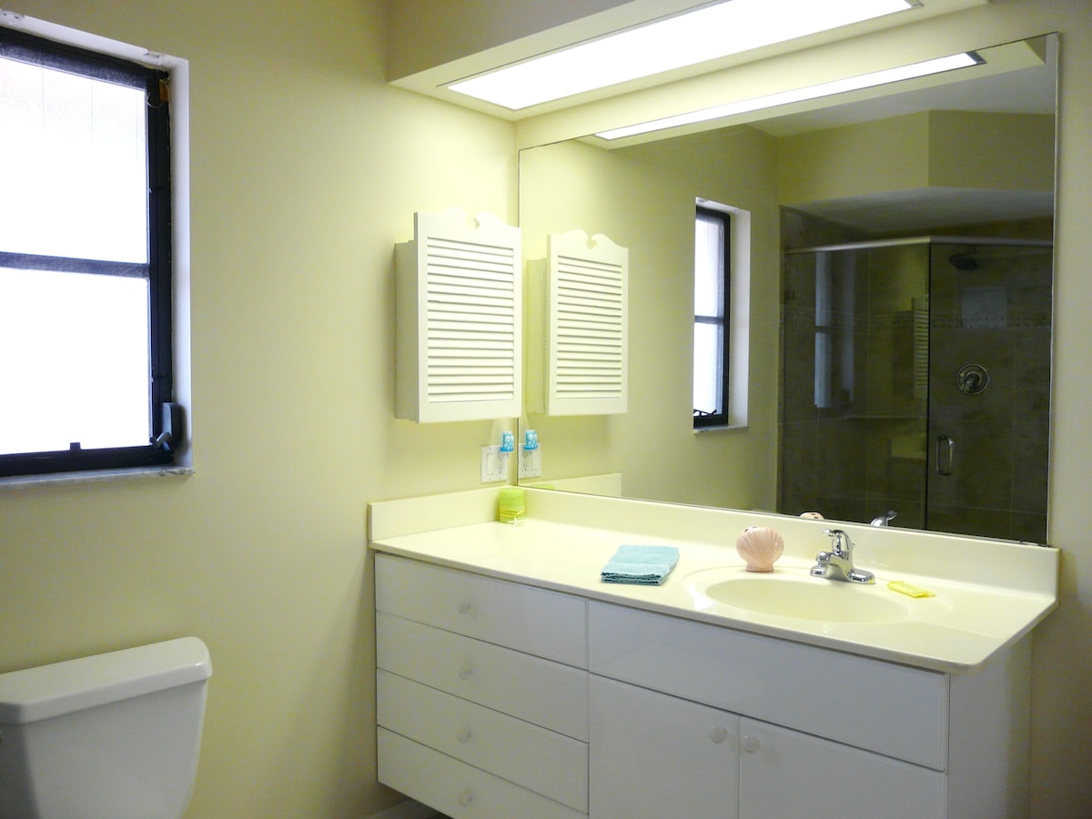 A bathroom with a white sink, a mirror, and a toilet.