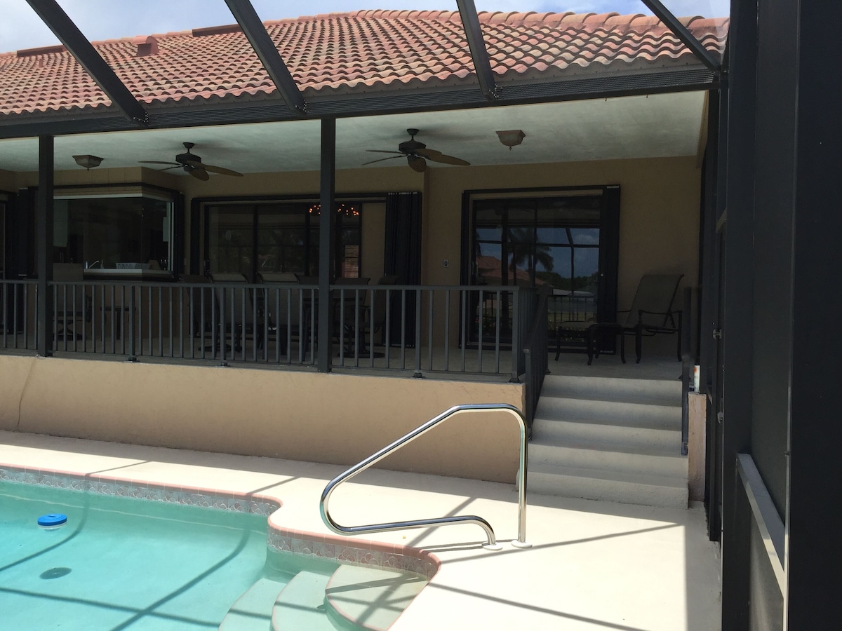 A covered outdoor area with a pool, stairs, and seating.