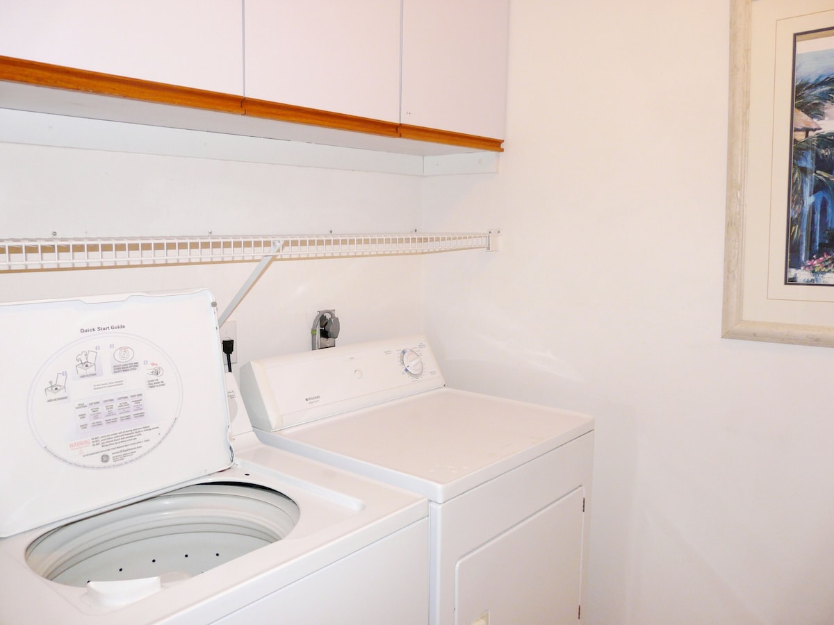 A white washing machine with a control panel and a circular door.