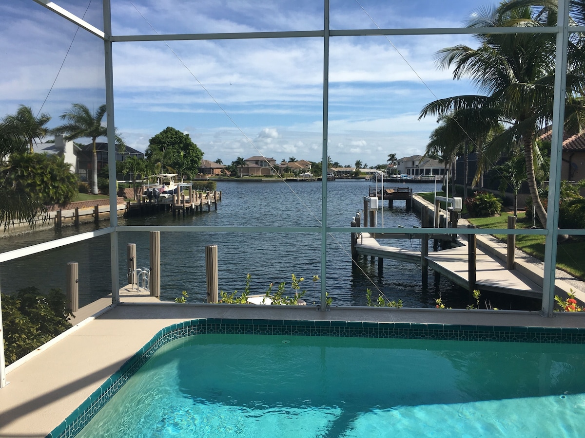 Pool edge and a wide canal view through the screen