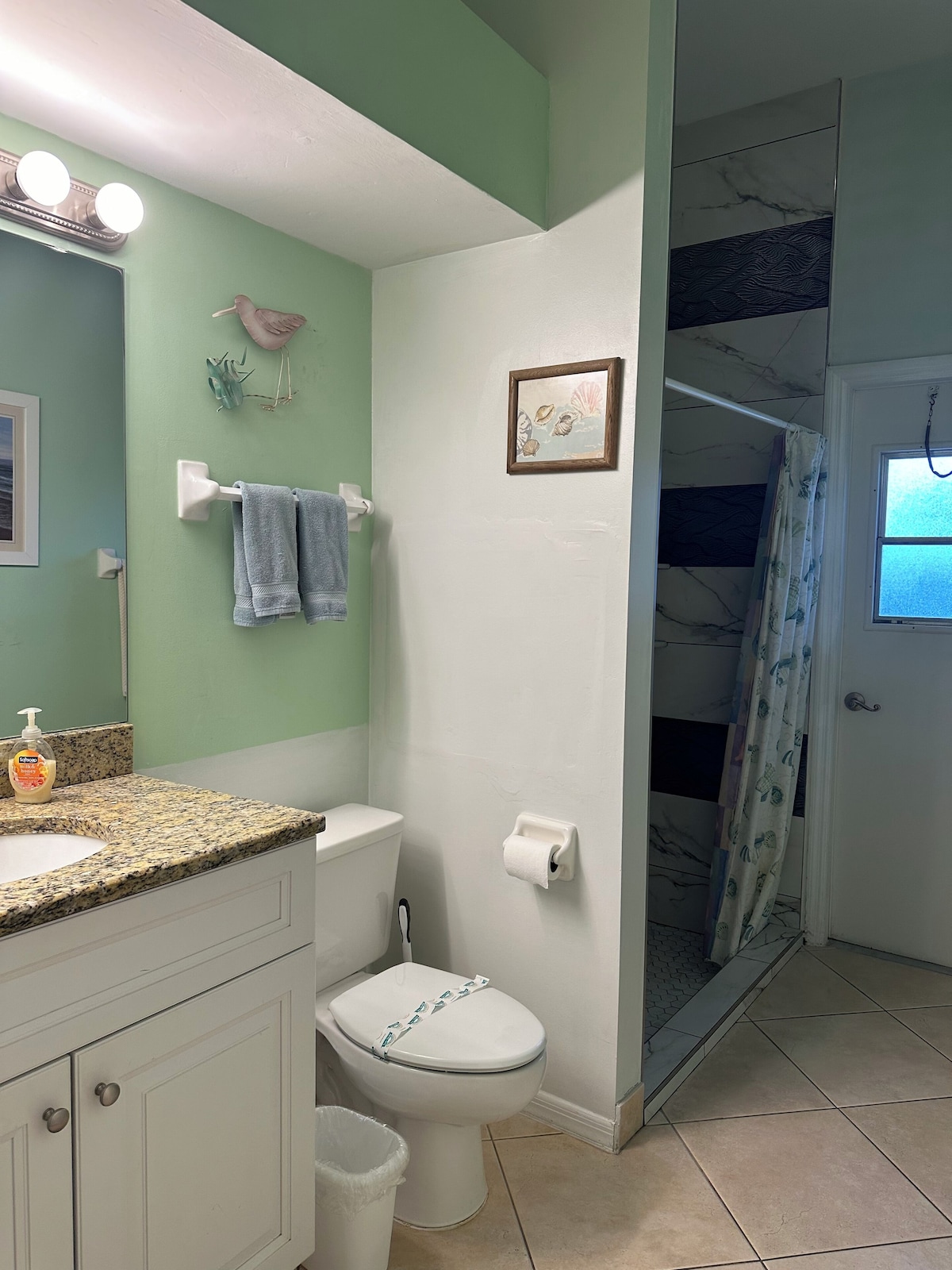 A bathroom with a toilet, sink, and shower area.