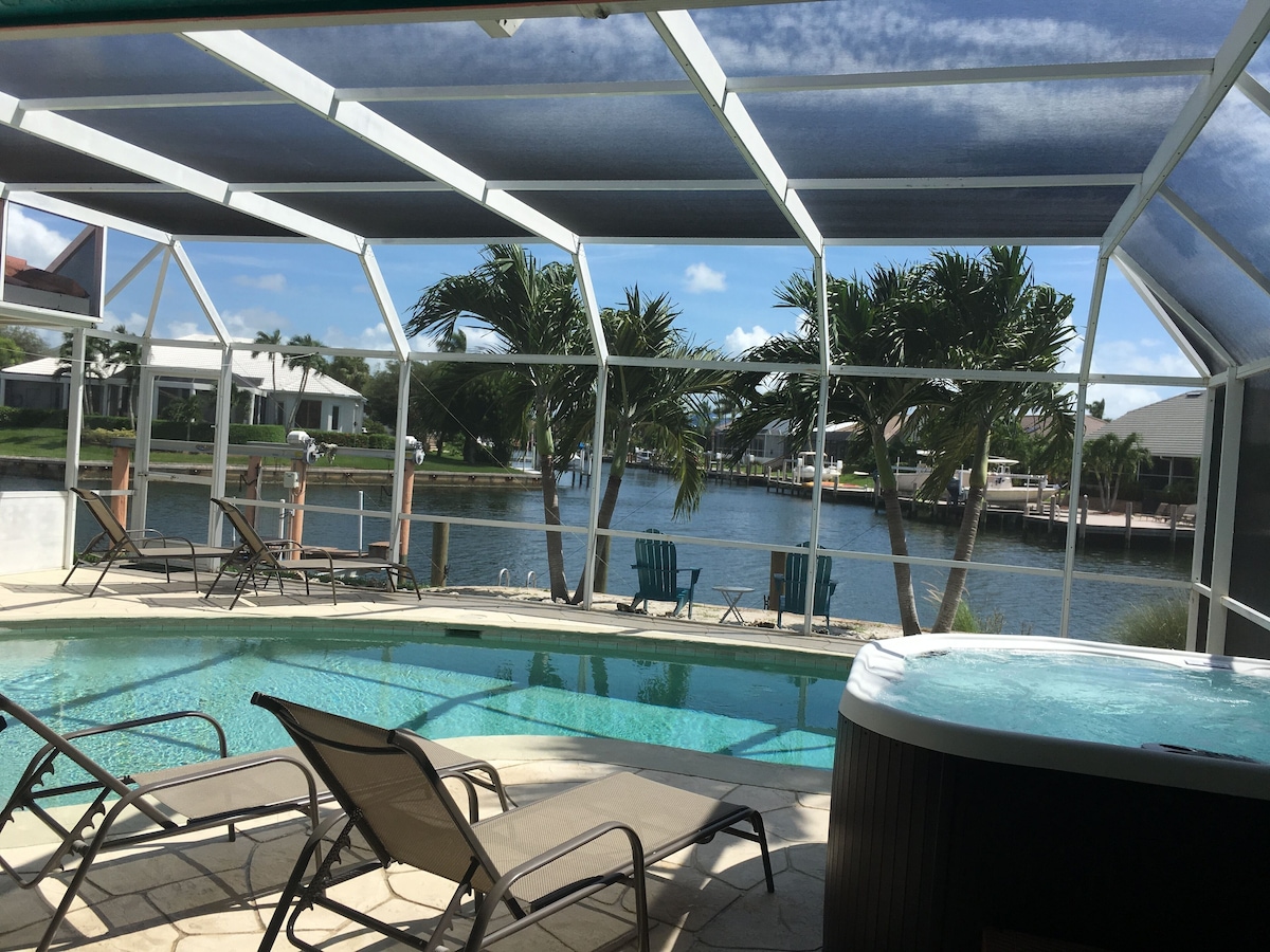 Heated pool and hot tub on a screened lanai by the canal