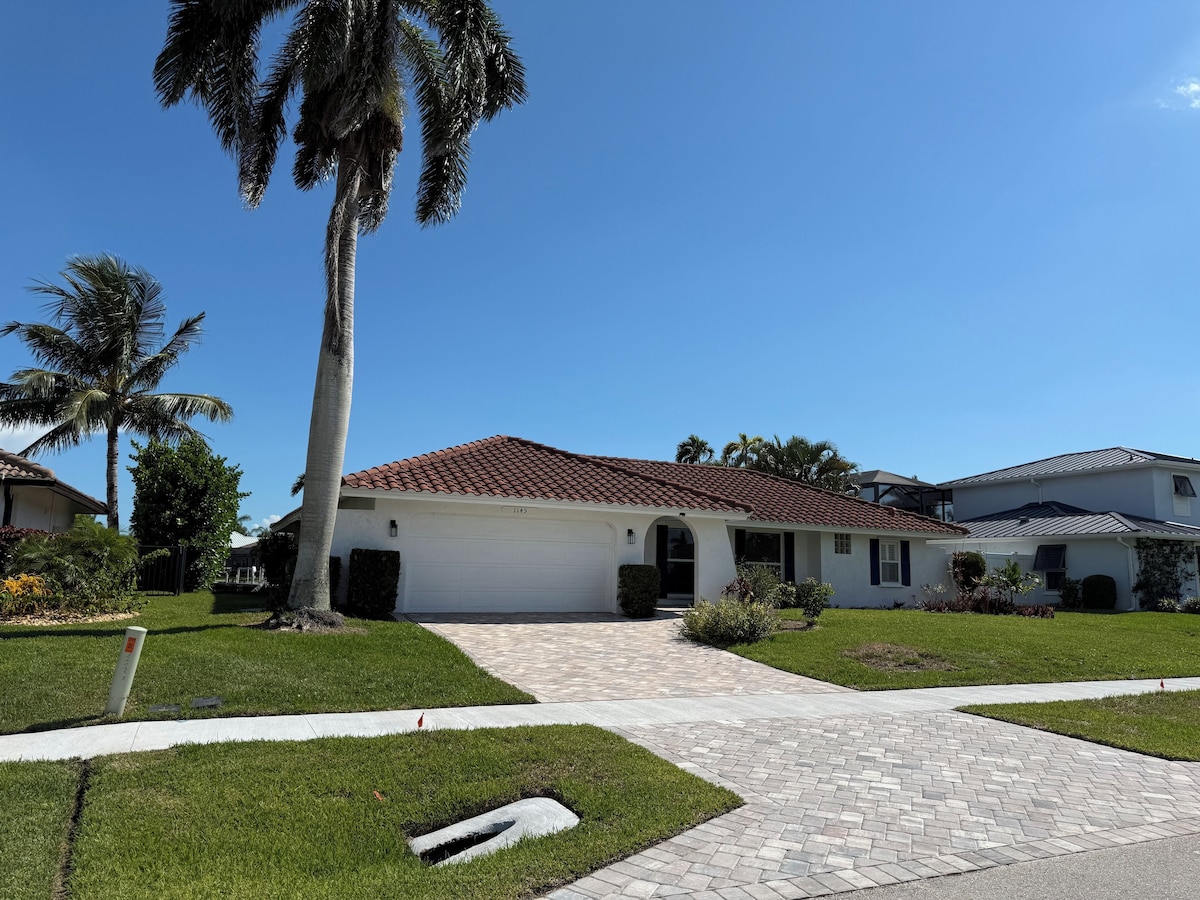 A single-story house with a tiled roof, a garage, and a well-maintained lawn.
