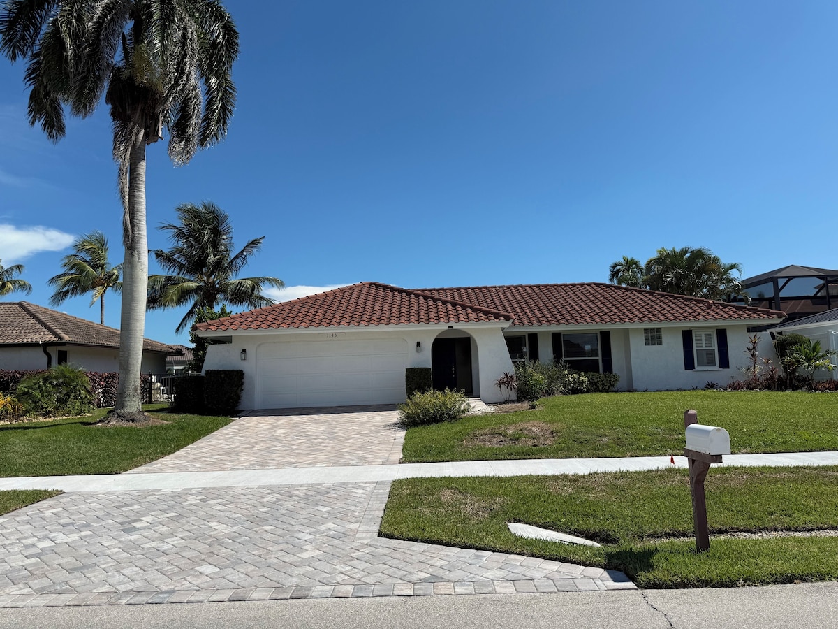 A single-story house with a red-tiled roof, a garage, and a well-maintained lawn.